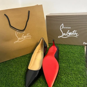 Svarta pumps från Christian Louboutin - Säljer ett par ikoniska svarta pumps från Christian Louboutin med glansig finish i skinn och den klassiska röda sulan. Skorna har spetsig tå och smal hög klack som ger en elegant siluett. Perfekta för dig som vill sticka ut med lyxig design.