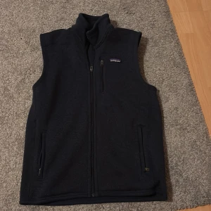 Patagonia fleeceväst - Blå fleeceväst från Patagonia med hög krage och hel dragkedja framtill. Mycket bra skick använd runt 5 gånger, perfekt till höstens stiliga färger. Hör av dig vid funderingar, priset är inte hugget i sten! 