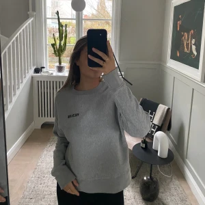 Grå sweatshirt från Zadig & Voltaire - Snygg grå sweatshirt från Zadig & Voltaire med svart Voltaire-tryck på bröstet. Material i mjuk bomull som är perfekt för chill dagar. Enkel och stilren design.