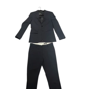 Mörkblå kostym från H&M - Använd endast 1 gång. Finns nån liten fläck på knät men går nog bort i tvätt. 