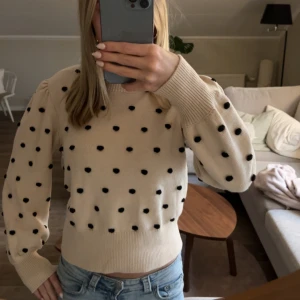 Beige stickad prickig tröja - Superfin beige stickad tröja med svarta prickar och puffiga långärmar. Tröjan har breda muddar vid ärmslut och midja, vilket ger en snygg passform. oanvänd ❤️nopprar inte i materialet 