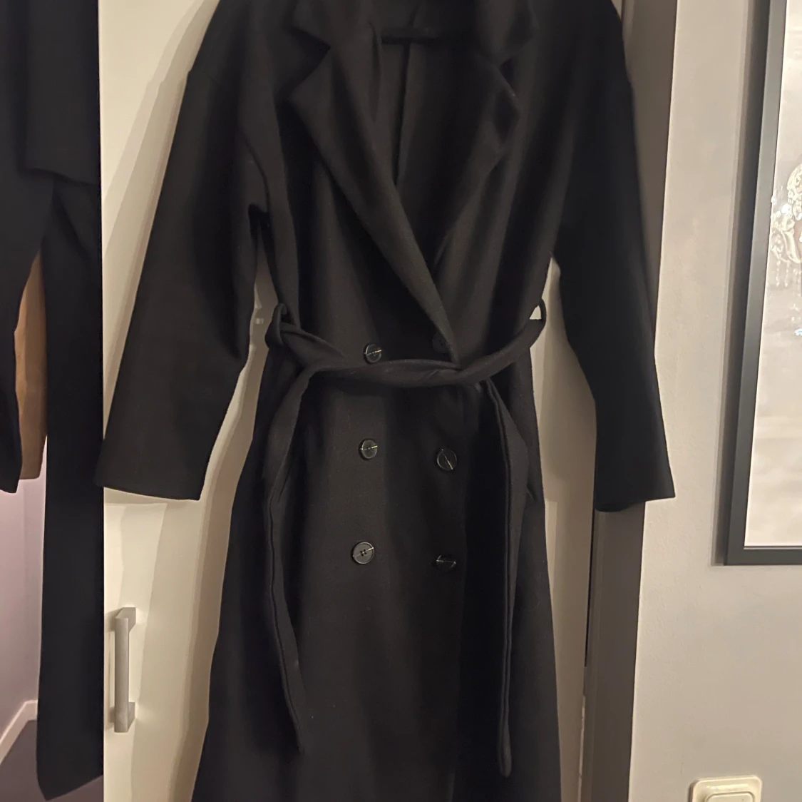 Svart kappa med bälte och knappar