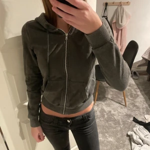 Mörkgrå hoodie med dragkedja från divided  - Mörkgrå hoodie med dragkedja framtill och huva med snörning. Tröjan har två fickor på magen.