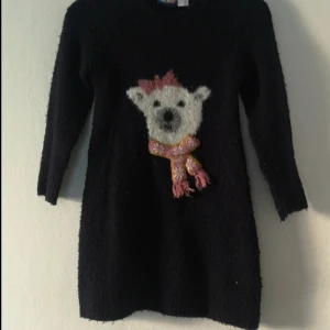 Svart/mörkblå klänning eller lång tröja - Mysig svart/mörkblå klänning från Lupilu i storlek 98/104. Framsidan har ett fluffigt motiv på en isbjörn med rosa rosett och halsduk.