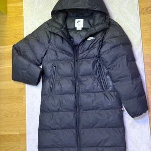 Nike svart dunjacka - Nike lång dunjacka den är i ett mycket bra skick kan skicka extra bilder om det behövs.