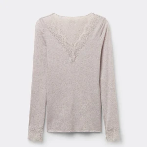 Intimissimi tröja - Aldrig andvänd prislapp kvar. Säljer en ljusbeige långärmad topp med v-ringning och fina spetsdetaljer vid halsringningen och ärmsluten från Intimissimi. Toppen har en slim passform och är tillverkad i mjukt material som känns skönt mot huden. Perfekt för dig som gillar stilrena och romantiska plagg.