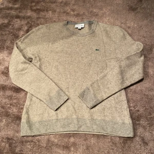 Lacoste stickad tröja - Grå lacoste stickad tröja i grå färg. Storlek m. Fast är lite krymt. Annars fint skick