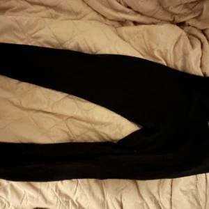 Svarta korta leggings med spetskant - Svarta korta leggings med smal passform och snygg spetsdetalj längst ner vid bensluten. Perfekta för dig som gillar en enkel men ändå lite extra look. Mjukt material som sitter skönt mot huden och ger en tight siluett.