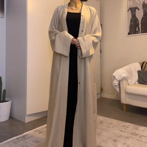 Beige lång kofta/abaya med vida ärmar - Säljer en stilren beige kofta/abaya med rak passform och extra vida ärmar. Den är hel lång och har diskreta knappar framtill. Perfekt för dig som gillar minimalistisk och clean look. Den är mjuk och lätt, har fickor och passar en som är ca 170 cm lång. ❤️