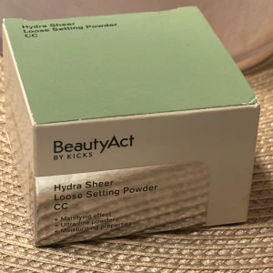 BeautyAct Hydra Sheer Setting Powder - Hydra Sheer Loose Setting Powder CC från BeautyAct by Kicks. Ett ultrafint, löst puder med mattande effekt och återfuktande egenskaper. Kommer i en stilren grön och beige förpackning. Perfekt för att fixera din makeup och ge en naturlig finish.