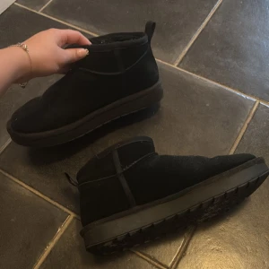 Svarta skor - Säljer ett par (fejk uggs) svarta boots i mocka med platt sula och rund tå. Skorna har en låg siluett och är fodrade på insidan för extra värme. Perfekta för kalla dagar💕 i storlek 38