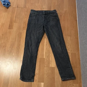 Svarta loose fit jeans Jack & Jones - Säljer ett par svarta loose fit jeans från Jack & Jones, modell Loose/Chris. Jeansen har klassisk femficksdesign, raka ben och är tillverkade i slitstarkt denim. Perfekta för dig som gillar en avslappnad och bekväm stil.