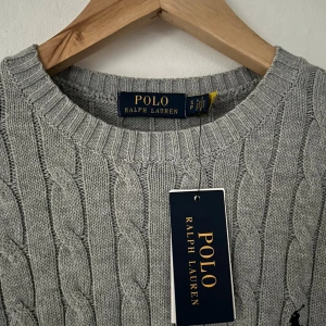Grå kabelstickad tröja Polo Ralph Lauren - Snygg grå kabelstickad tröja från Polo Ralph Lauren. Storlek S. Tröjan är tillverkad i 100% bomull. Perfekt nu till vintern. Kontakta vid mer frågor eller funderingar🙌