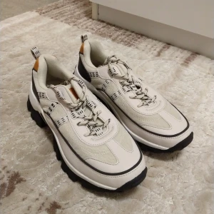 Chunky beige sneakers - Säljer ett par chunky sneakers i beige och vitt med svarta detaljer och grov, mönstrad sula.