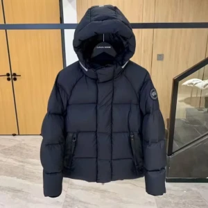 Svart pufferjacka från Canada Goose - Säljer en svart pufferjacka från Canada Goose med huva och två fickor med dragkedja. Jackan har ett quiltat mönster och logotyp på ärmen. Perfekt för kalla dagar med sin tjocka och fluffiga design. Reflekterande detalj på huvan och insida med märkning. Obs! Jackan är en kortare modell, så kallad pufferjacket.