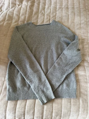 Grå stickad tröja från Vero Moda - Mysig grå stickad tröja från Vero Moda med rund halsringning och ribbade muddar vid ärmslut och nederkant. Perfekt för lager på lager och enkel att matcha till olika outfits. Tillverkad i mjukt material som känns skönt mot huden.