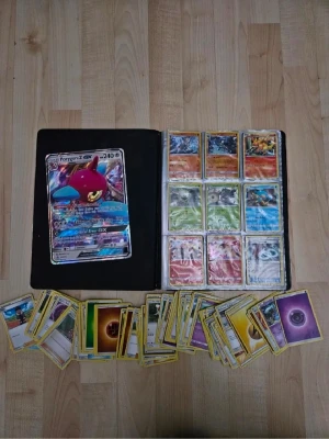 Pokémonkort  - Stor samling Pokémonkort i en pärm med färgglada kort, inklusive en stor Porygon-Z GX och flera olika energikort och karaktärer. Pärmen har ett tryck med Pokémonmotiv och innehåller både vanliga och holografiska kort. Perfekt för dig som vill bygga din samling eller spela TCG. Priset kan duskuteras