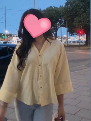 Ljusgul skjorta från Zara - Säljer en ljusgul blus med avslappnad passform och trekvartsärmar. Blusen har V-ringning, knappar framtill och är tillverkad i ett lätt, luftigt tyg som passar perfekt till jeans eller kjol.