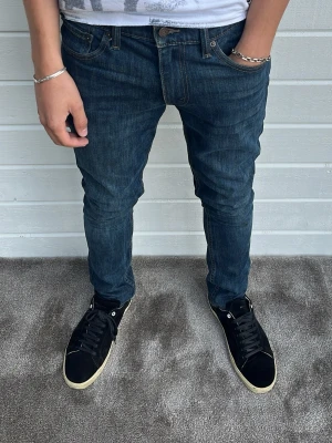 Levis 511 jeans mörkblå - Hej! Säljer dessa slitstarka levis jeans i mycket bra skick! Modellen på bilden är 183cm och väger 68kg. Passformen heter 511 och är slim. Storlek: W32/L32. 99% bomull och 1% elastan. Hör av dig!