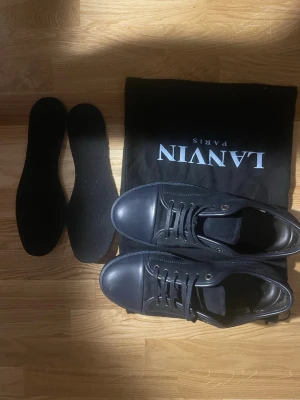 Lanvin skor 40 - Säljer nu ett par snygga lanvin skor i storlek 40 men passar upplever att de passar lite större också. Otroligt bra skick endast använda 1gång.. Ett par stilrena skor som passar till lite finare tillfällen. Man får även med extra sulor och dustbag. Självklart äkta✅