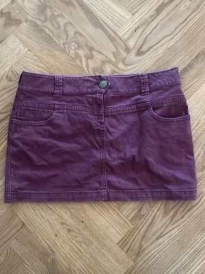 Lågmidjad minikjol - Superfin vinröd / lila jeanskjol med stor guldknapp och fina bakfickor! Passar tyvärr inte mig:( midja: 43-44cm och längd är 35,5 cm💕💕