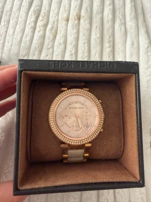 Guldig Michael Kors klocka med stenar - Michael kors klocka, sparsamt använd. Batterier är slut så de behöver man byta. 