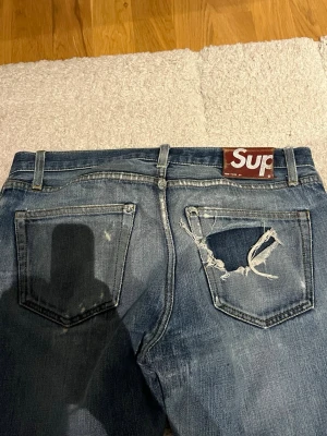 Supreme jeans - Säljer dessa supreme jeans. Jag har lagat jeansen vilket du kan se på sista bilden. Väldigt sällsynta och riktigt snygga. Storlek är W32 L34, i CM midja 44cm och längden 104cm. 