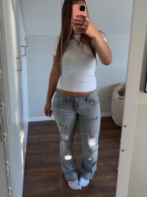 Ljusgrå slitna raka jeans - Säljer ett par ljusgrå jeans med hål på framsidan , jeansen är i storlek 40 men passar mig som har 37/38 perfekt hålen har ja gjort själv och jeansen är från Gina !💓