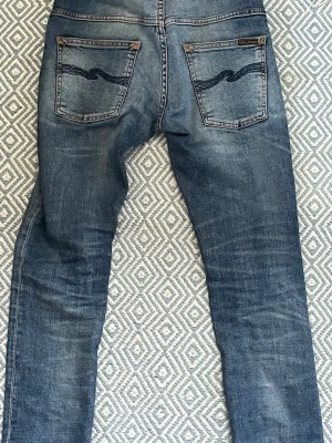 Nudie jeans slimfit w27/32 - Ett par stilrena Nudie jeans med snygg tvätt dem är i gott skick. Perfekt nu till hösten för stilrena outfits, stilen är grisch/archive och är enkelt att kombinera med andra plagg. För dig som är ~165-180. Kontakta om frågor!