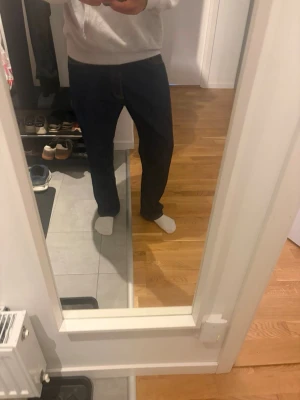 Levi's 501 raka blå jeans - Klassiska blå Levi's 501 jeans med rak passform och fem fickor. Jeansen har den ikoniska läderlappen bak i midjan och röda Levi's-märket på bakfickan. Tillverkade i slitstark denim med gul kontrastsöm.