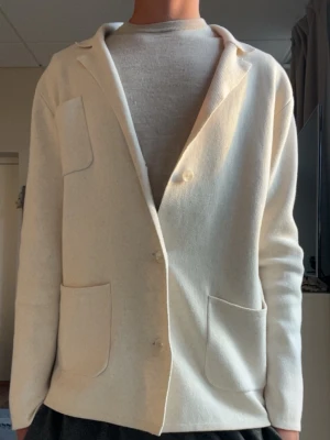 Stickad kavaj/cardigan - Säljer en beige/krämvit stickad kavaj/cardigan från John Henric, perfekt till både casual och mer uppklädda tillställningar. Varan är i mycket bra skick utan skavanker eller slitage. Storlek M, pris 650kr!