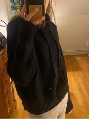 Svart stickad hoodie - Mysig svart stickad hoodie. Tröjan har avslappnad passform, perfekt för chill dagar och enkel att matcha med allt.