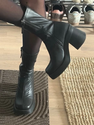 Steve Madden platåstövlar - Säljer mina svarta Steve Madden stövlar med chunky platå och bred klack. Stövlarna har dragkedja på sidan och är tillverkade i slätt skinnliknande material. Klacken är 8cm och dessa är verkligen såså sköna att ha på sig, kan använda dem i timmar! Har verkligen älskat dessa men säljer då dem tyvärr inte är min stil längre. De har någon liten skråma som syns på bilden men annars är dom helt i nyskick🥰🥰