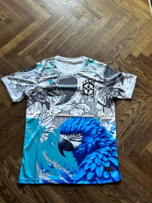 Brasilien Fotbolls T Shirt ”Blue Parrot” - Brasilien Fotbolls T shirt, Storlek S, Perfekt för fotbolls älskare. Har aldrig använt den och den är i topp kvalité. 