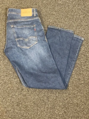 Replay blå jeans – fint begagnat skick - Replay-jeans i klassisk blå tvätt. Stilrena och bekväma med en tidlös passform.  Fint begagnat skick med normalt slitage från användning. Inga hål, fläckar eller andra större anmärkningar. Tyget och sömmarna är i bra skick.  Perfekta som ett par vardagsjeans och enkla att matcha med det mesta. Nypris 1300kr  Storlek: W33 L32 Skick: 8/10