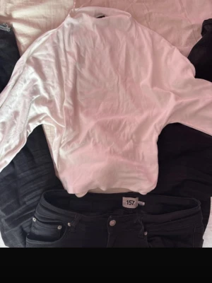 Vit topp från Gina Tricot - Säljer en enkel och stilren vit topp från Gina Tricot i storlek M. Toppen har lång ärm och fin krage, perfekt att matcha med jeans eller kjol. Materialet känns mjukt och stretchigt, vilket gör den bekväm att bära hela dagen.