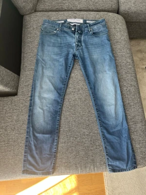 Blå jeans från Jacob Cohën - Snygga blå jeans från Jacob Cohën med klassisk femficksmodell och raka ben. Jeansen har en lätt tvättad look och är tillverkade av exklusivt denimtyg med italienskt hantverk. Perfekta för dig som gillar stilrena och tidlösa jeans.