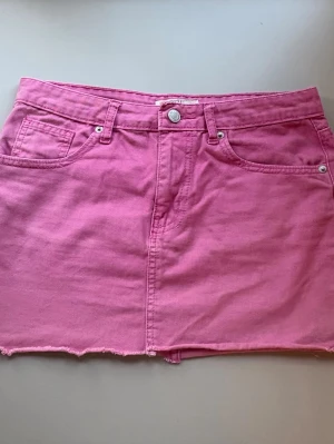 Rosa jeanskjol med rå kant - Snygg rosa jeans kjol från Don’t think twice. Den har några lösa trådar på ena sida men annars i bra skick. 