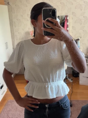 Vit blus från GinaTricot  - Säljer en vit fin blus från GinaTricot i storlek XS men passar även S. Toppen är figurnära i midjan och har även ett fint material. Den är knappt använd. Säljer för 160kr då den är köpt för 300kr och i bra skick. 