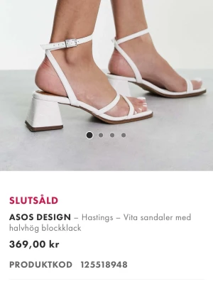 Vita sandaler med blockklack - Stilrena vita sandaler med smala remmar och halv­hög blockklack. Sandalerna har fyrkantig tå, justerbart spänne vid ankeln och en trendig minimalistisk design. Tillverkade i konstläder med slät finish och bekväm innersula.