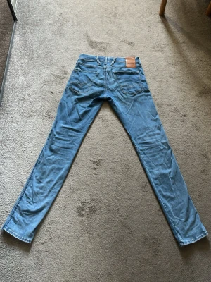 Blå Replay Hyperflex jeans - Säljer ett par riktigt snygga ljusblå Replay Hyperflex jeans pga för små för mig. Bra skick och inte använda super mycket! Skriv vid funderingar eller prisförslag🕺W30 L32