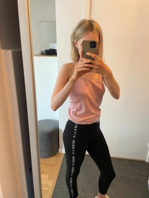 Svarta träningsbyxor i bomull från Nike - Säljer ett par svarta träningsbyxor från Nike i storlek M med vit text längs båda benen. Aldrig använda. 50 kr!