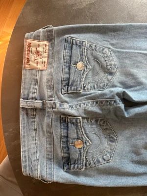 Ljusblå bootcut jeans True Religion - Säljer ett par ljusblå jeans från True Religion Joey low rise flare i storlek 24 då de tyvärr inte passa längre. Använda 4 gånger. Org pris är 1299kr