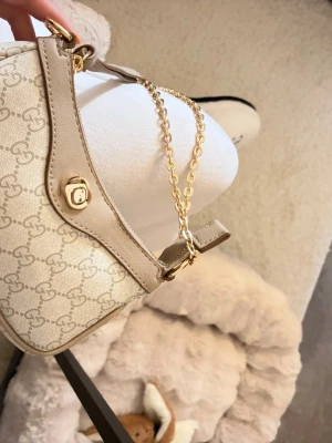 Axelväska  - Helt ny väska i beige med guld detaljer. Skriv pm för fler bilder på den