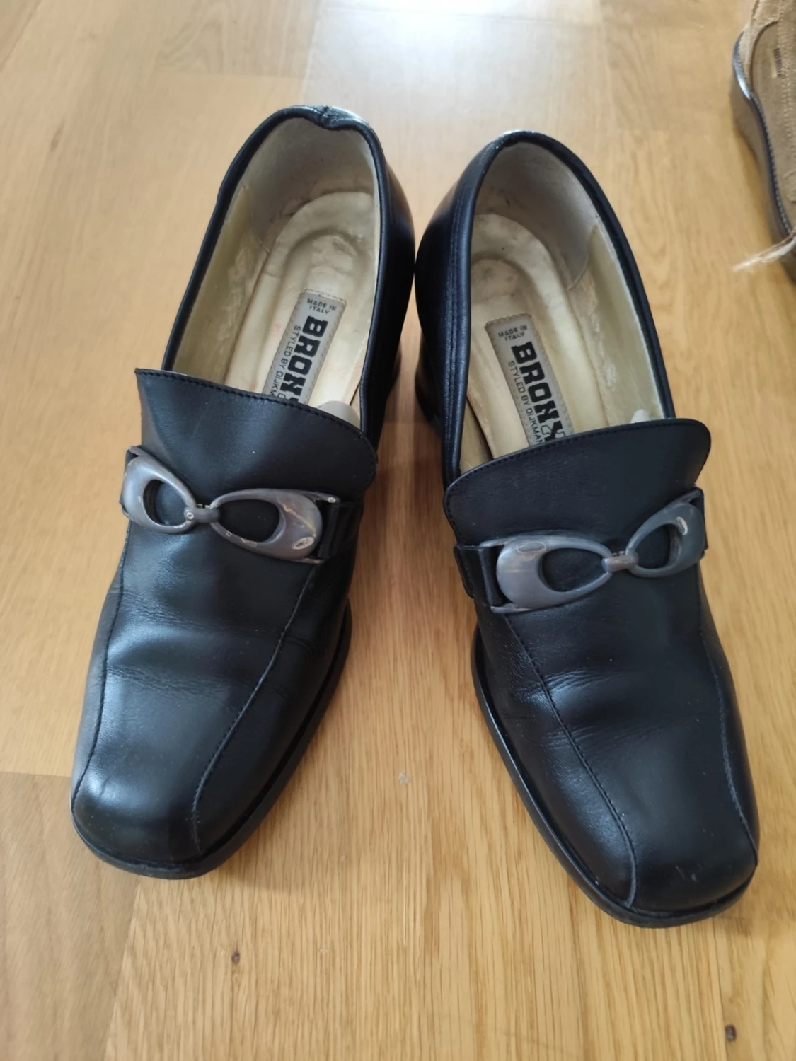 Svarta loafers med klack och metallspänne