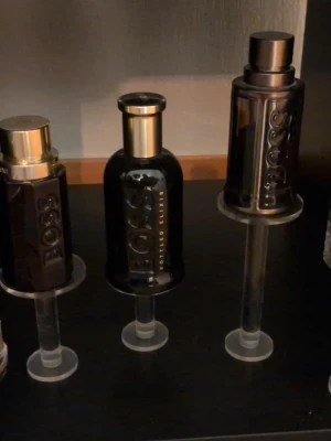 Svart parfymflaska från BOSS - Samling av exklusiva parfymer med eleganta flaskor i guld och glas. Flera flaskor har geometriska former och detaljer som metall, krona och reliefmönster. Designen är modern och sticker ut med glänsande ytor och unika lock. (Intresse koll) Säg till så kan vi komma överens om bra pris, fler köp bättre pris.