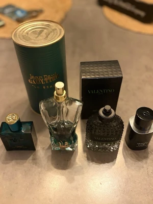 Parfymset med Jean Paul Gaultier & Valentino - Säljer ett parfymset med flera exklusiva dofter. Bland annat Jean Paul Gaultier Le Beau i blå glasflaska formad som en manlig torso, Valentino parfym i svart mönstrad flaska samt ytterligare två eleganta flaskor i mörka färger. Perfekt för dig som vill ha variation i din doftgarderob. Mitt pris 1995 men priset kan diskuteras vid snabb affär. Jean Paul rymmer hela 125 ml, valentino rymmer 100ml, Versace rymmer 50ml och Armani rymmer 50ml. Hur mycket det är i får ni uppskatta. Armani ca 15 ml kvar