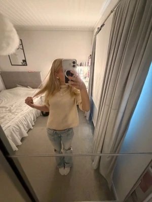 Beige croppad topp med kort ärm - Säljer en beige croppad topp med korta ärmar och rund hals. Toppen har en enkel och clean look som passar perfekt till jeans eller kjol. Använd 1 gång 