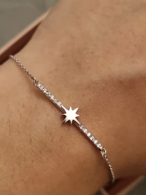 Silverarmband med stjärndetalj - Snyggt och tunt armband i silverfärg med en stjärnformad detalj i mitten. Armbandet har en rad små gnistrande stenar längs en del av kedjan som ger extra bling. Perfekt för dig som gillar minimalistisk och trendig stil.