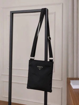 Prada Nylon Crossbody - Prada Nylon Axelväska (Vintage) - Äkta Prada axelväska i klassisk svart nylon med ikoniska triangelloggan framtill. Enkel, stilren och perfekt för både vardag och resa. Justerbart axelband. Modellen är unisex och väldigt lätt att bära. Väskan är i fint begagnat skick (7–8/10) – inga stora defekter, bara normalt slitage. En tidlös favorit som inte tillverkas längre!